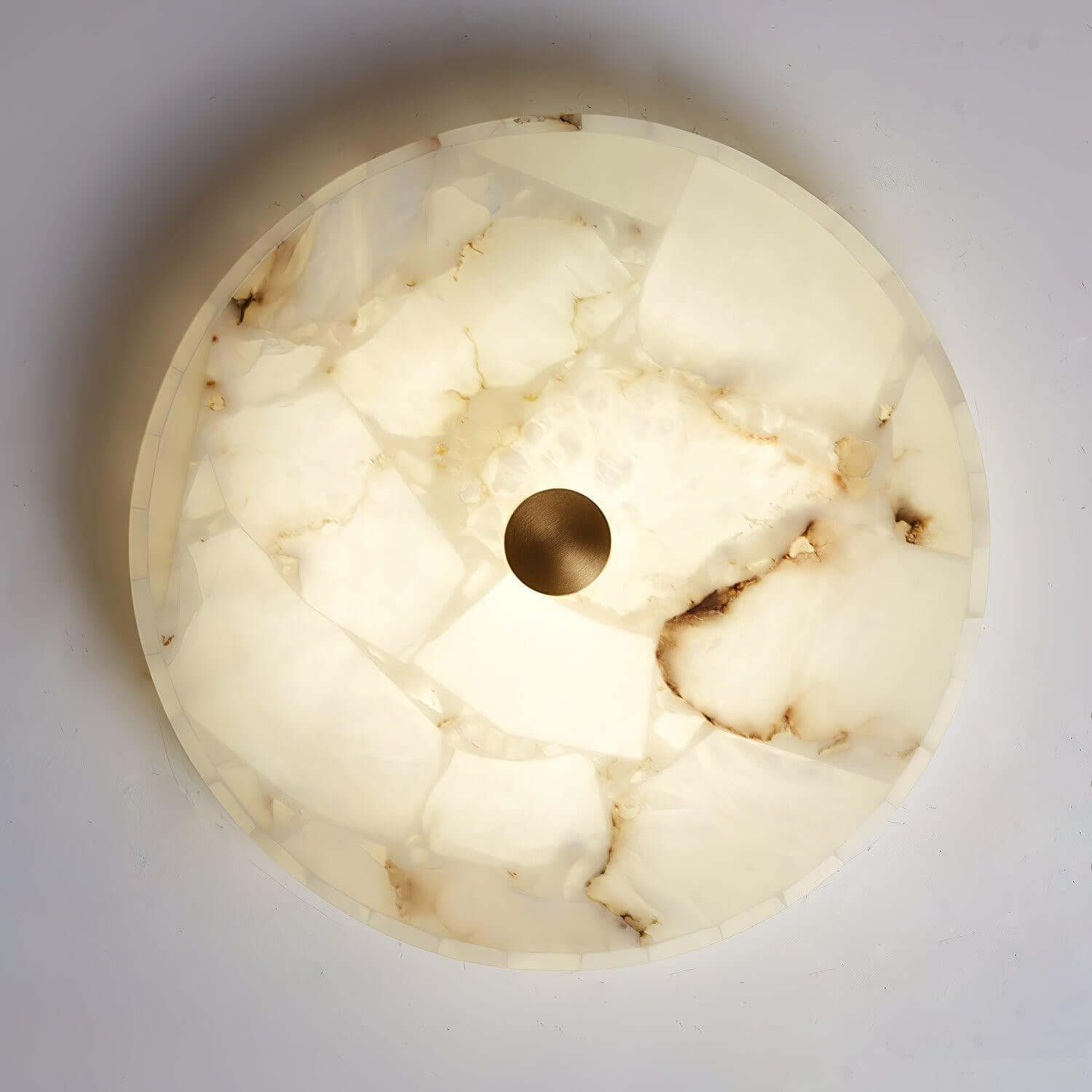 Round LED ceiling light in alabaster with a sleek flush mount design, ideal for bedroom illumination.