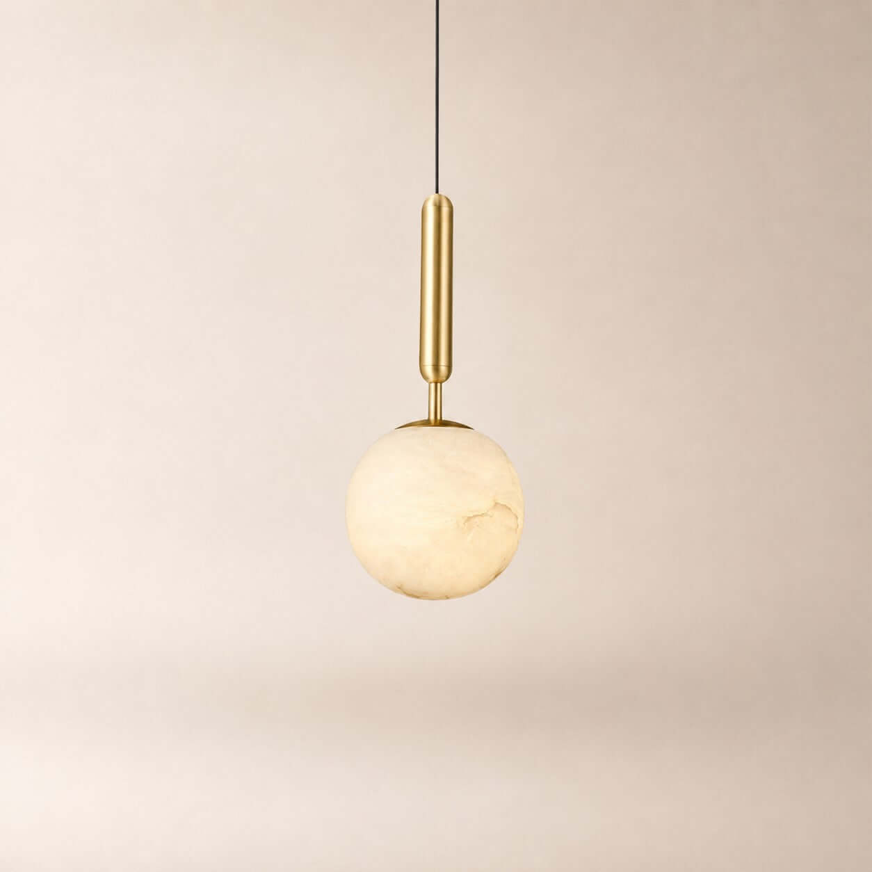 Velriq alabaster globe pendant light with a brushed brass stem and black suspension cord