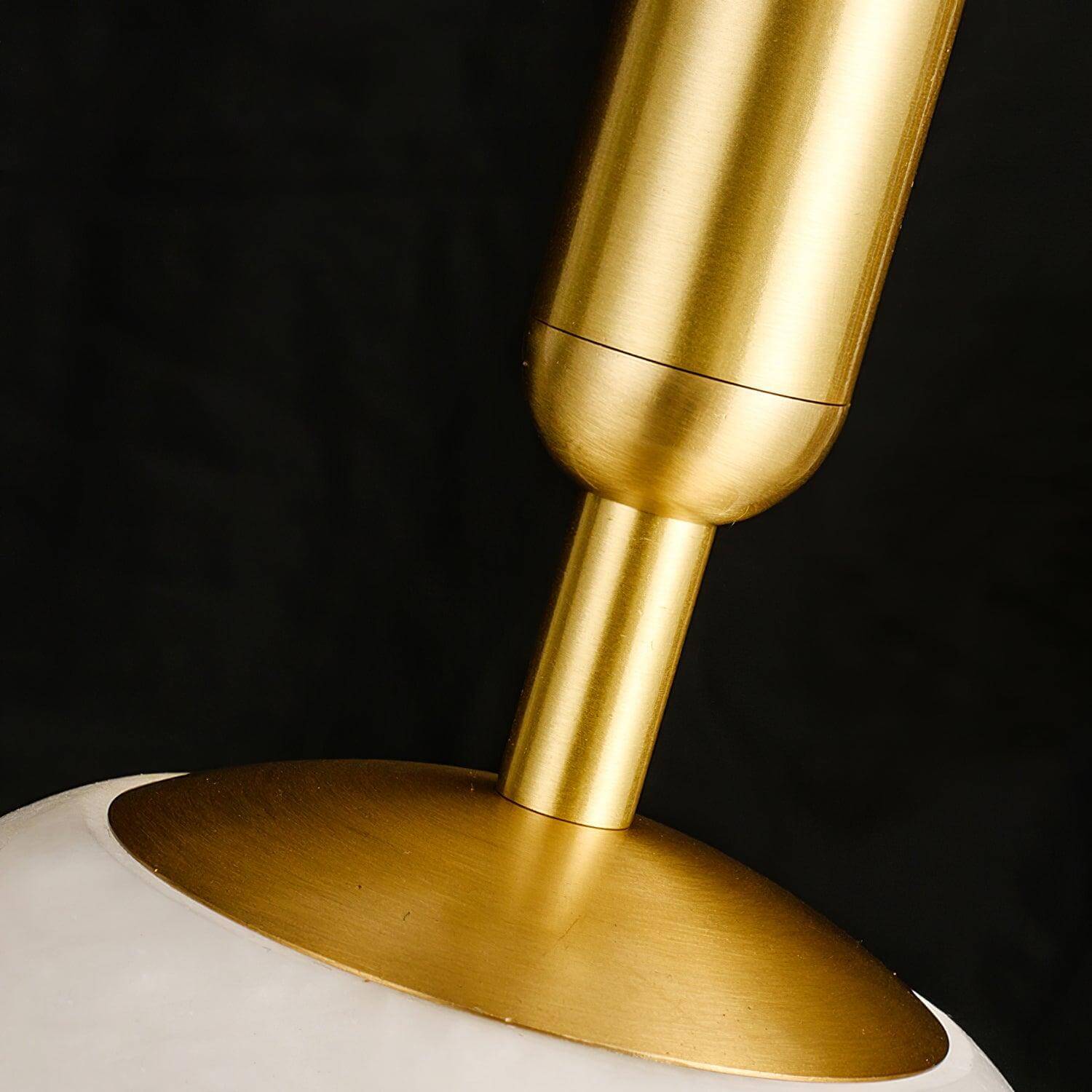 Close-up of the Velriq pendant light’s brushed brass stem and shade connection