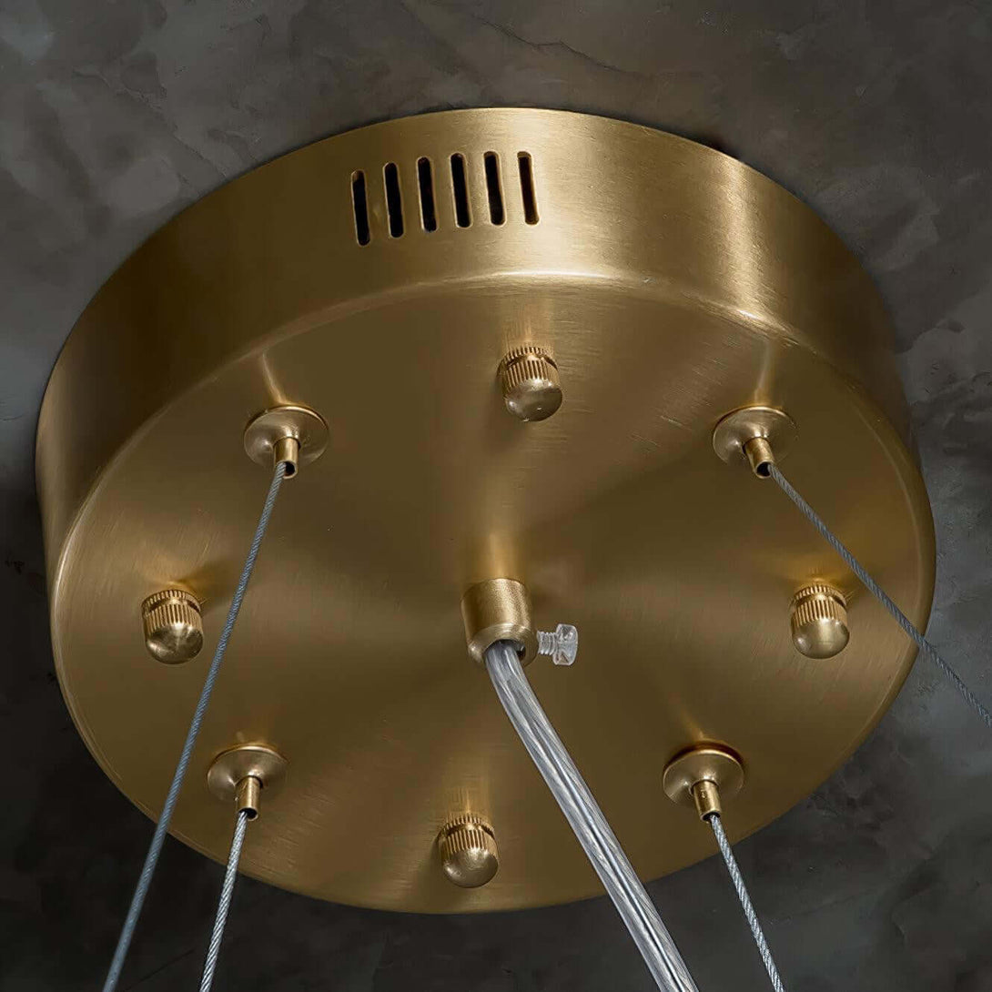 Close-up of a decorative brass ceiling plate for a chandelier, showcasing modern design and elegant finishes.