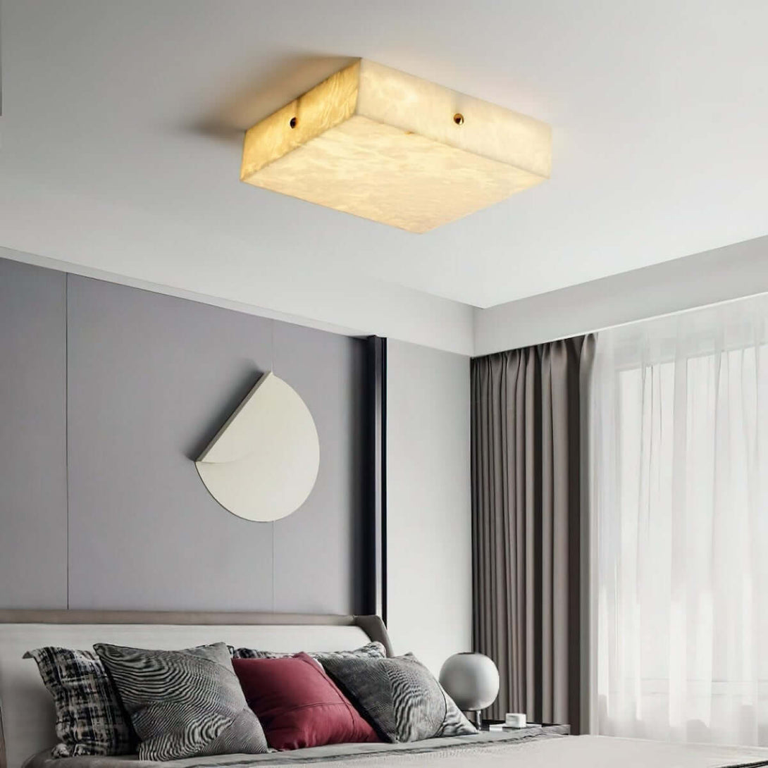 Zymero modern square flush mount ceiling light in alabaster, illuminating a stylish bedroom interior.