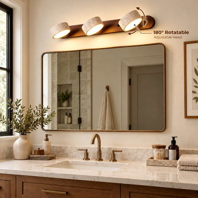 Avenor three-light travertine vanity light in a walnut finish above an arched bathroom mirror and dark wood vanity.