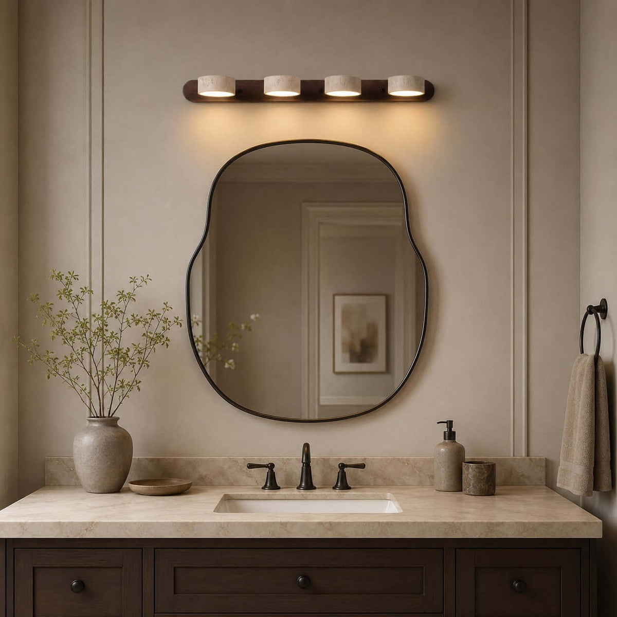 Avenor two-light travertine wall light switched off above a stone console table beside an entryway staircase.