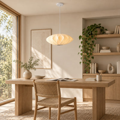 Corvya white silk pendant light above a wood desk in a sunlit home office with open shelving and a woven chair.