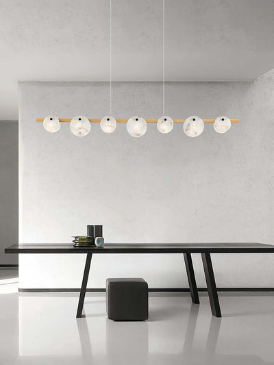 Frumix alabaster chandelier with 7 spherical lights over a modern dining table, showcasing mid-century modern lighting.