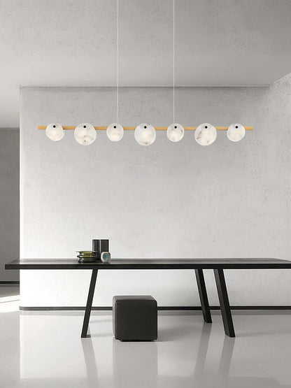 Frumix alabaster chandelier with 7 spherical lights over a modern dining table, showcasing mid-century modern lighting.