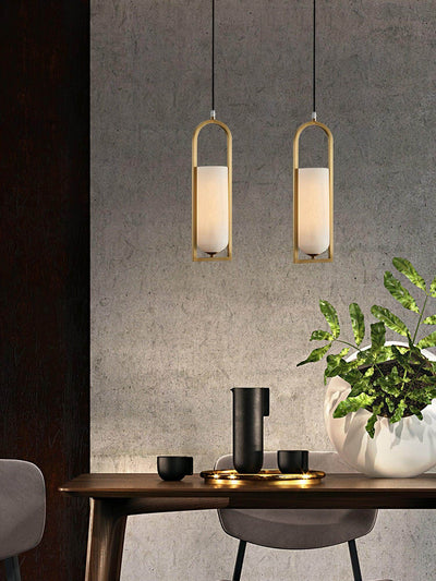 Orleni pendant light in a modern dining setting, featuring alabaster lamps and sleek brass accents.