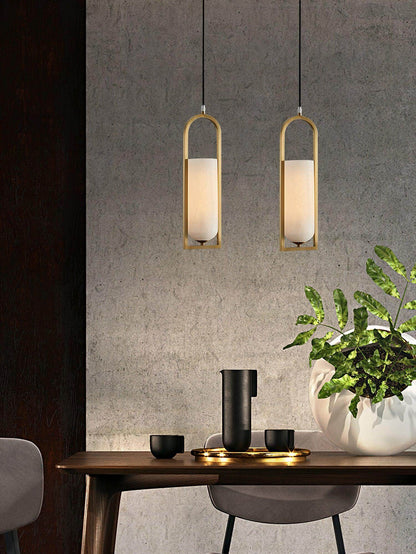 Orleni pendant light in a modern dining setting, featuring alabaster lamps and sleek brass accents.