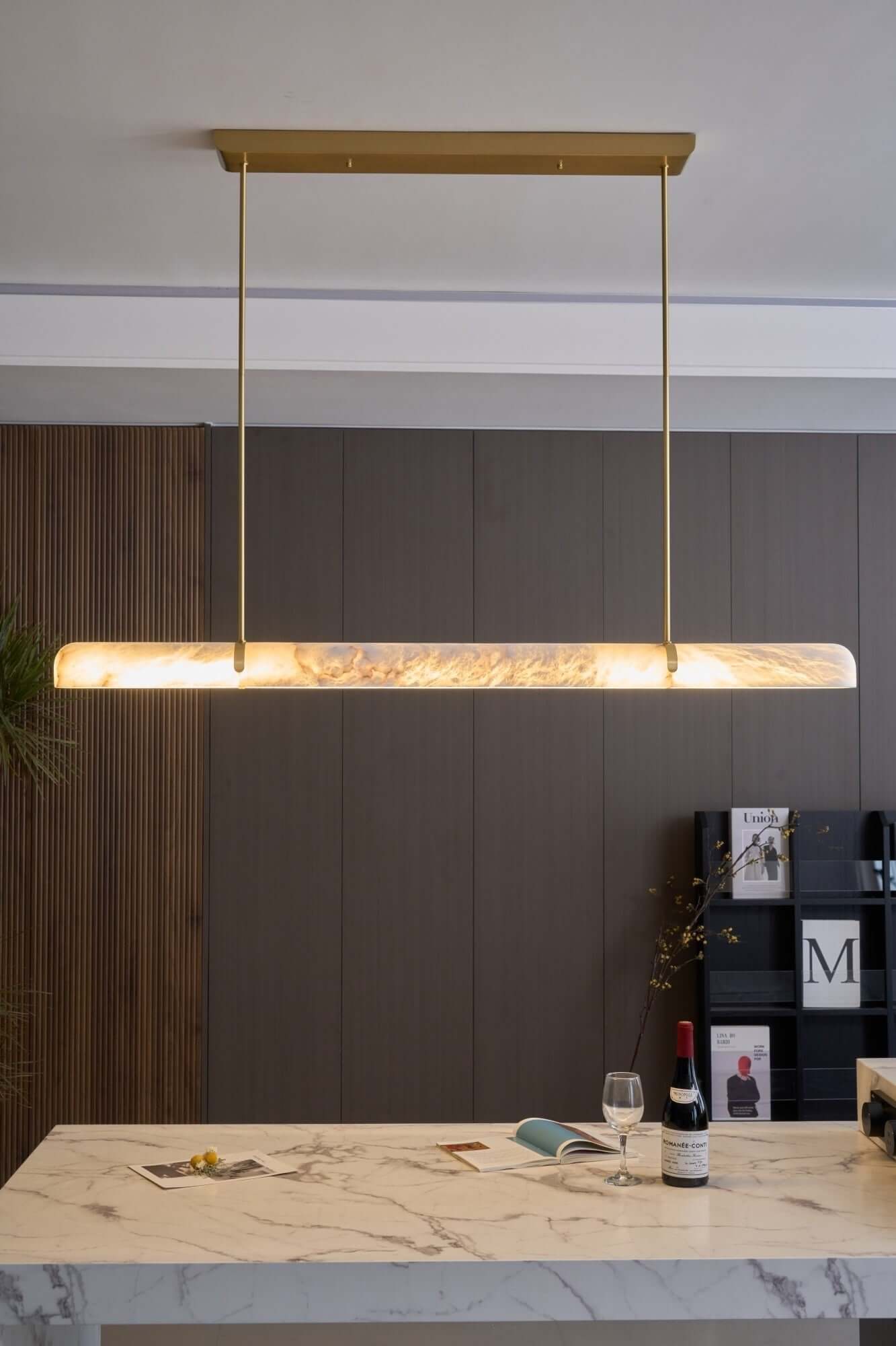 Qemir chandelier over a dining table, modern linear alabaster light fixture for stylish dining rooms.