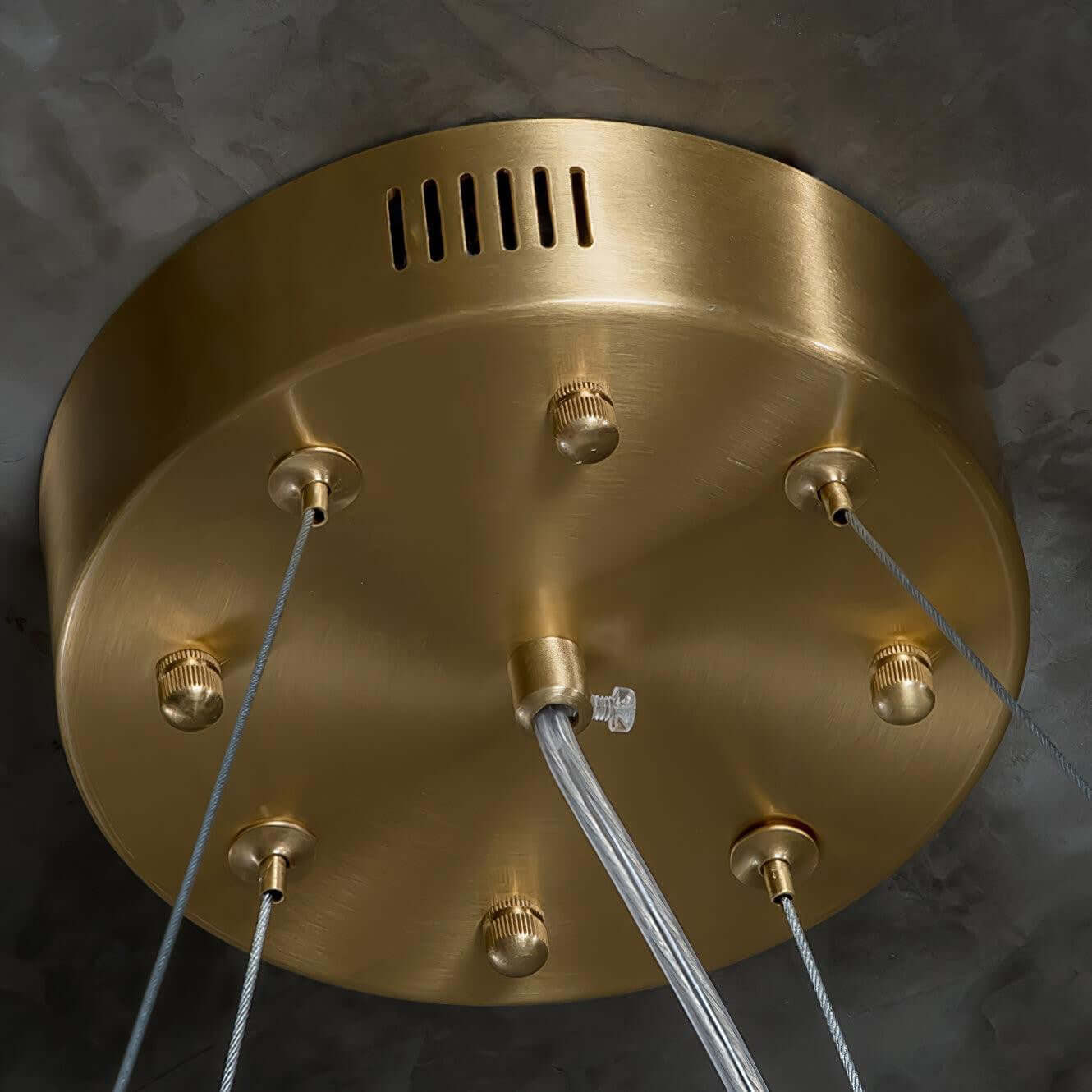Close-up of a decorative brass ceiling plate for a chandelier, showcasing modern design and elegant finishes.