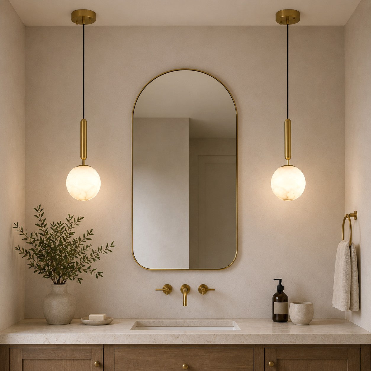 Two Velriq alabaster pendant lights flanking an arched mirror above a stone vanity