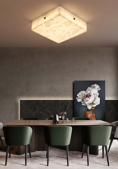 Zymero alabaster flush mount ceiling light illuminating a modern dining area with stylish green chairs.