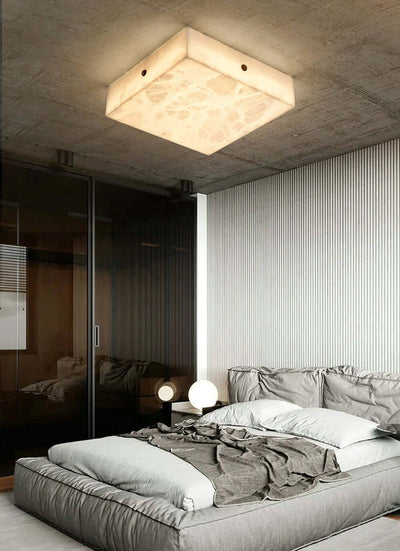 Modern alabaster flush mount ceiling light in a stylish bedroom setting, enhancing contemporary decor.